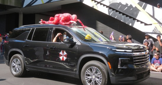Umbrella Corporation SUV with red zombie body attached to the roof.