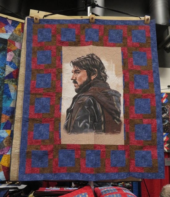 Red and purple quilt, but in the center is a picture of Diego Luna as Cassian Andor.