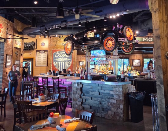 Same antique auto near ceiling, above bar.