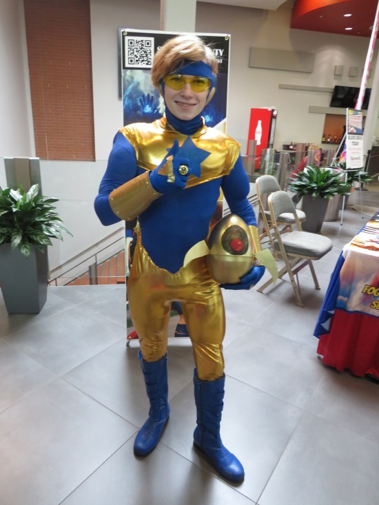 Booster Gold cosplayer with homemade Skeets mini-robo-ship.