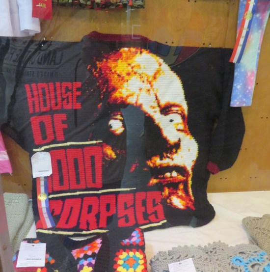 Black blanket with logo and scary bug-eyed man from the Rob Zombie movie in the caption.