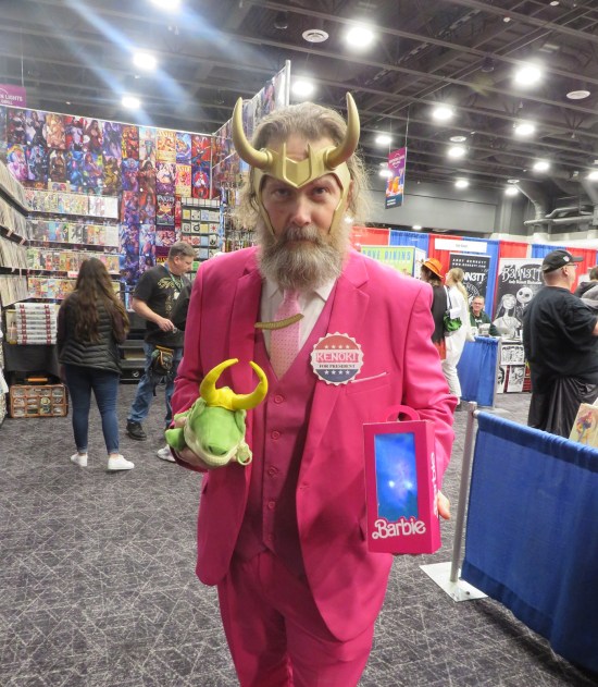 cosplay mash-up of Loki helmet, pink business suit, alligator Loki puppet and "Kenoki for President" button.