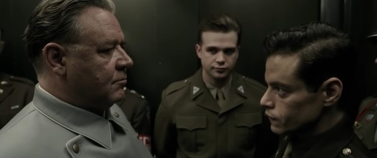 Russell Crowe faces off against Rami Malek while Leo Woodall stands in the background.