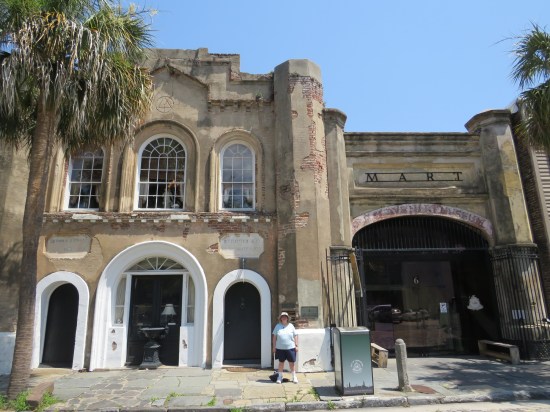 Anne standing in front of the Old Slave Mart Museum, frowning because she's tired and dehydrated after a mile's summertime walk.