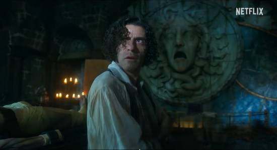 Oscar Isaac as Victor Frankenstein, staring offsceen in horror, his face lit up by lightning in an otherwise dark room.
