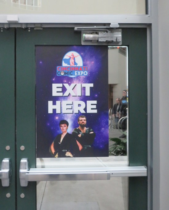 Purple sign labeled EXIT HERE with photos of Ursa and Non from "Superman 2".