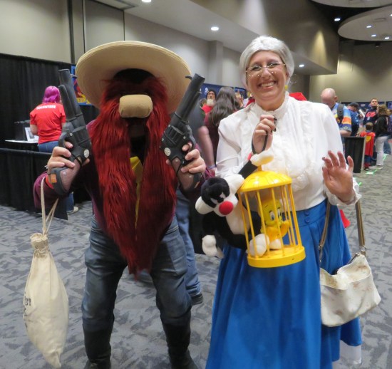 cosplayers: Yosemite Sam with pistol and Granny with Tweety in a cage.