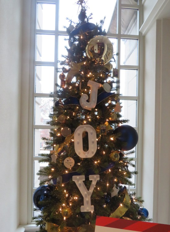 Christmas tree with large letters J, O, and Y hung on the front.
