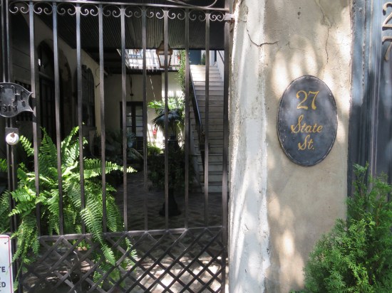 Fancy downtown southern home with metal gate and tropical plants in their entryway.