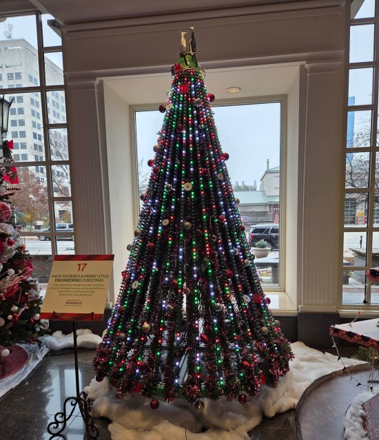 Christmas tree with strings of lights vertically hung from bottom to top instead of encircling it.