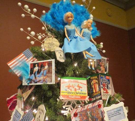 Christmas tree covered in "White Christmas" memorabilia, including pics and two Haynes Sisters dolls 