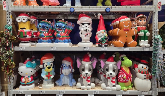 Two shelves of foot-tall Christmas lawn statues including Stitch, Santa Minion, Stormtrooper, Elf on the Shelf, Hello Kitty, Bluey, and more.