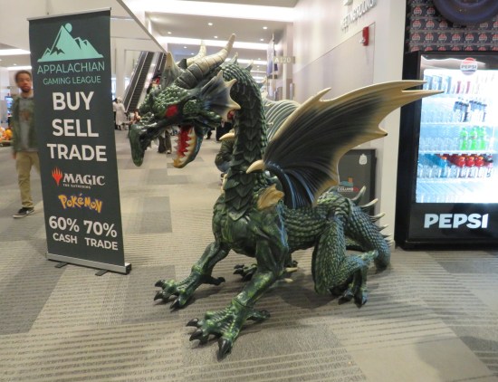 Five-foot-tall dragon statue next to a cooler full of bottled soft drinks.