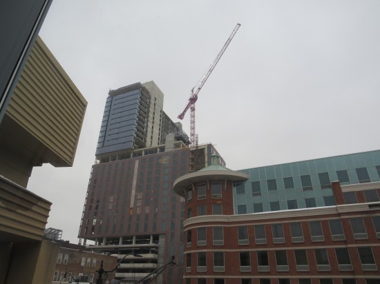 Odd-shaped buildings, some of them unfinished and with a crane looming overhead.