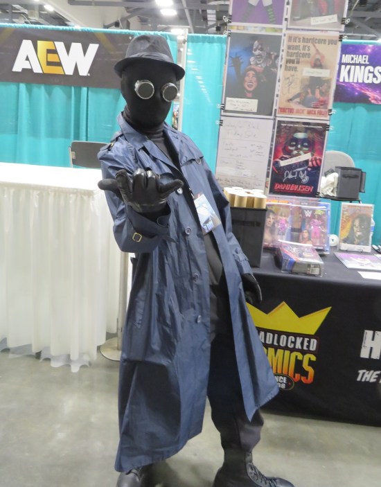 Spider-Man Noir costume in front of a wrestling booth.
