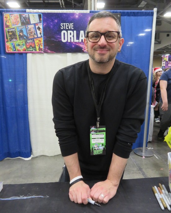 Steve Orlando at his booth, all in black.
