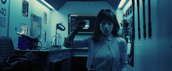 Robot woman sits in a blue-lit lab, yanks an A/V cord out of her head.