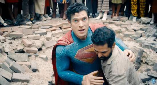 An Asian Samaritan helps Superman get up from his Superman-shaped sidewalk crater.