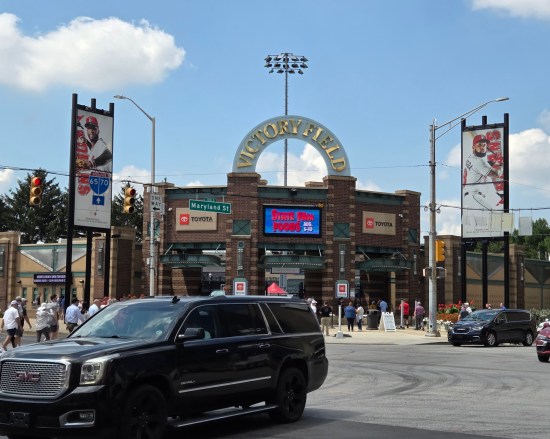 Entrance to Victory Field in Indianapolis, partially obscured by traffic. Sign above the center doors touts the Indiana State Fair.