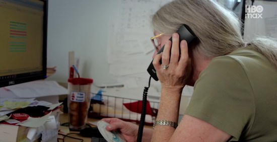 Woman over 55 takes office phone calls.