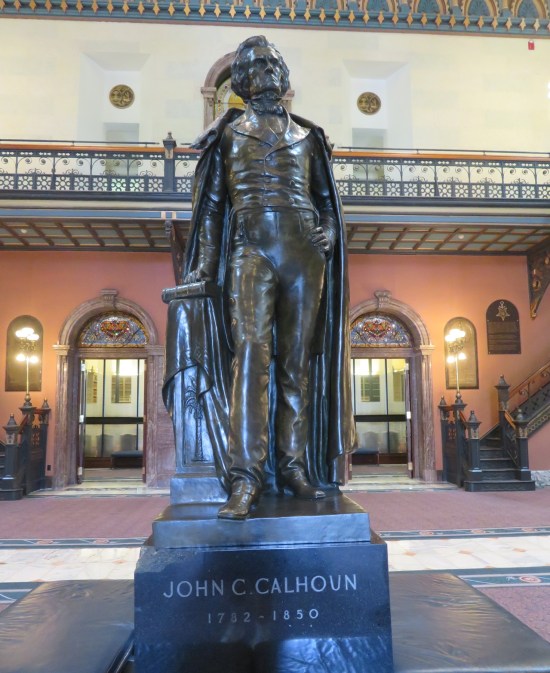 Closeup of John C Calhoun statue in the middle of the statehouse lobby.