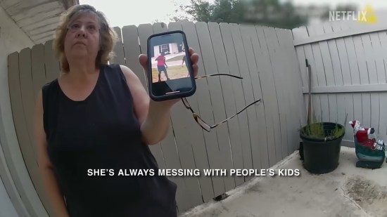 Bitter elderly woman holds up phone picture of Black child being a child.