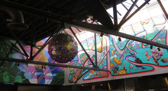 Gray ball hanging from ceiling, with purple lights scattered across it.