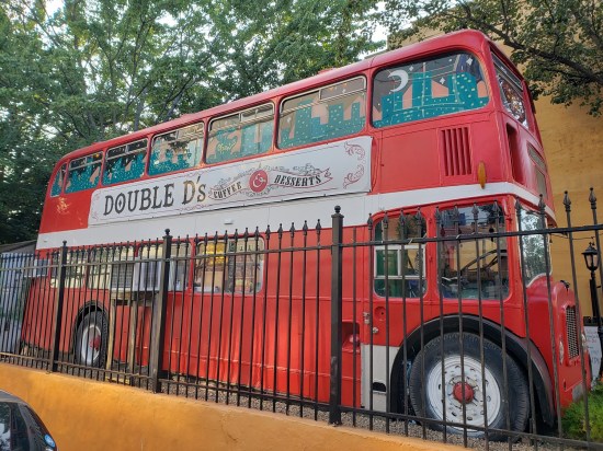 Double D's Coffee and Desserts, in a red double-decker bus. Second-story windows are painted with a cartoon nighttime cityspace.