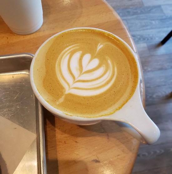 Latte with foam happy heart design on top.