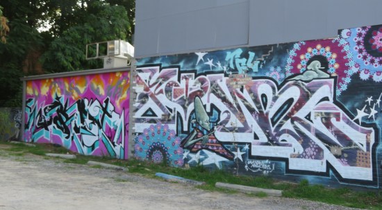 Street art across two adjacent buildings. All code, no discernible letters.