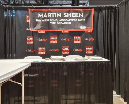 Martin Sheen's C2E2 booth, surrounded by black curtains. The only listed credits on his sign are "The West Wing", "Apocalypse Now", and "The Departed".