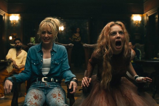 Two blond women tied in chairs in a mansion ballroom. One is dressed normally and confounded, the other is in a bloody wedding dress and screaming.