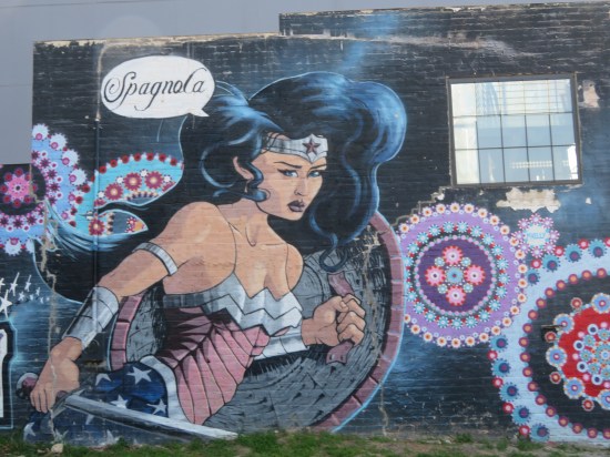 Wonder Woman mural, wielding sword and shield and saying "Spagnola" while surrounded by Spirograph circles.