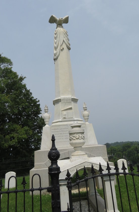 white obelisk on a hilltop with a stone eagle perched on it.
