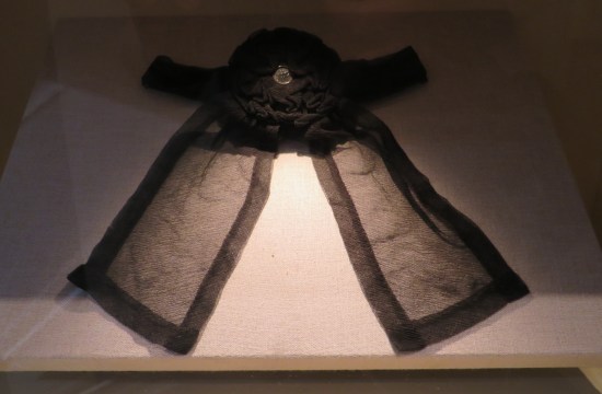 large black ribbon in a shadowy glass case.