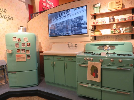 1950s kitchen with all turquoise appliances, but a modern flatscreen TV handing above the sink.