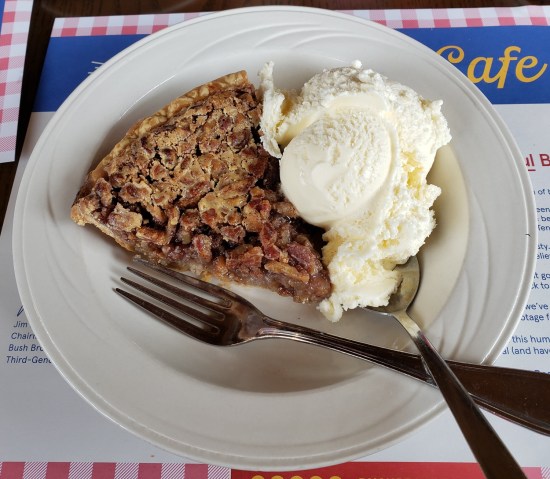 Pecan pie with scoop of vanilla ice cream.