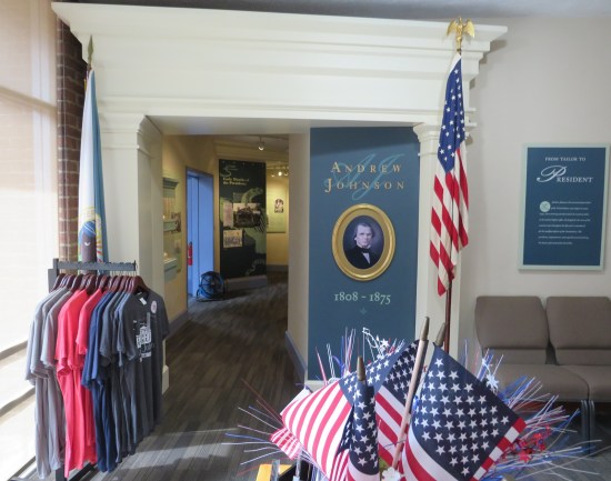 visitor center with Andrew Johnson site T-shirts, small US flags, and a hallway to a museum exhibit.