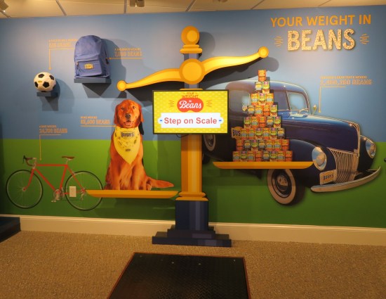 Children's museum scale labeled Your Weight in Beans. Several pics on the wall, including Duke.
