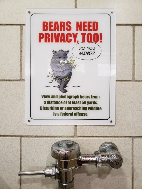 sign in men's room cautioning visitors not to approach bears in the wild.