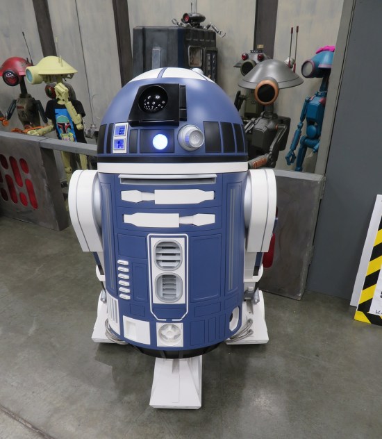 blue astromech droid parked in front of five other droids