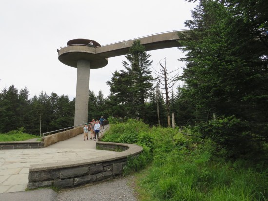 Long spiral ramp leading to a circular deck atop a tall tower. 
