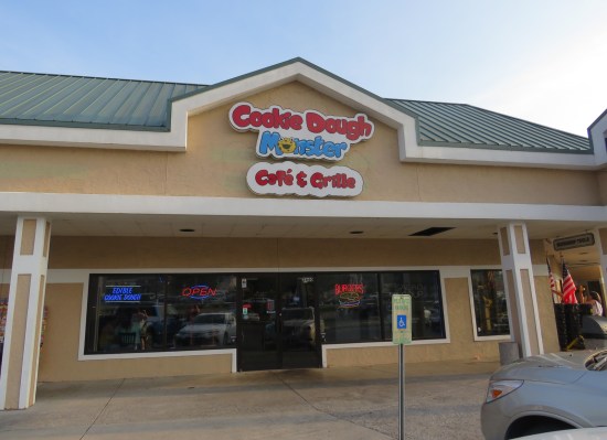 Cookie Dough Monster restaurant with neon signs boasting edible cookie dough, burgers, and "OPEN".