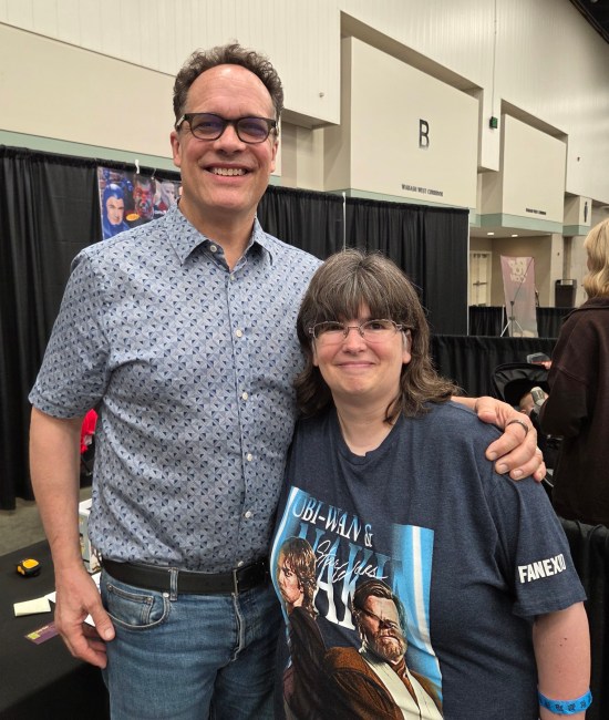 Diedrich Bader and Anne, posing cheerfully at his table.