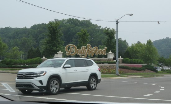 Large Dollywood sign by an intersection.