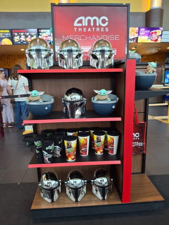 AMC kiosk with Mandalorian helmets, popcorn buckets, and 32-ounce cups.