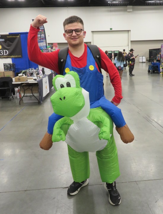 Mario costume riding an inflatable Yoshi.