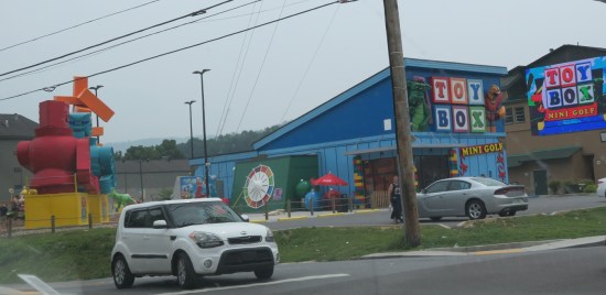 Toy Box Mini-Golf blue storefront with large replica childhood toys out front