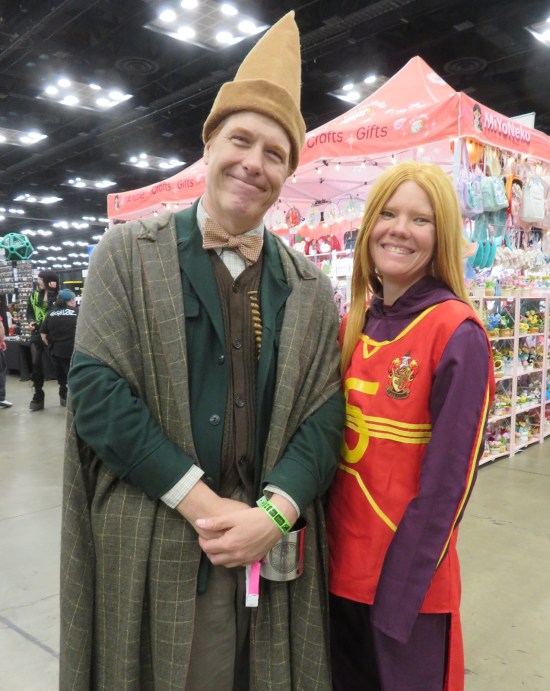 Arthur Weasley with pointy hat and Ginny Weasley in Quidditch uniform.