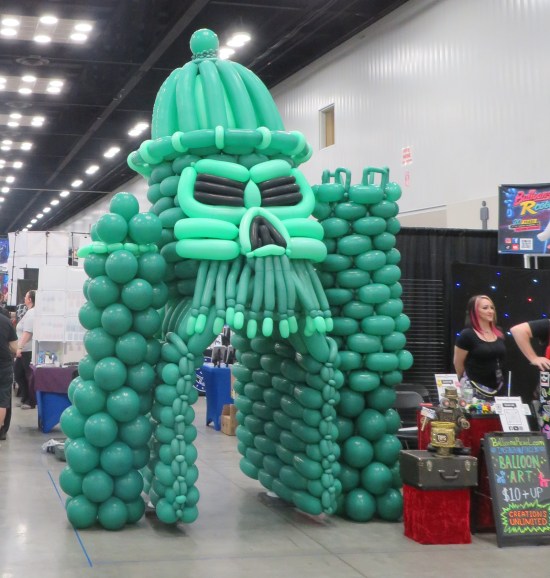 big Castle Grayskull made entirely of green balloons with black eye and nose holes.